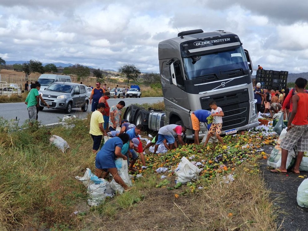 Caminhão com fruta tomba e população levam frutas que caiu do caminhão