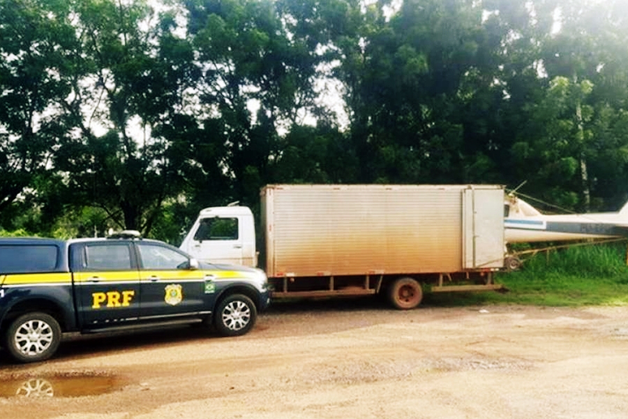 PRF flagra caminhão transportando um avião em um caminhão baú com a metade da aeronave para fora