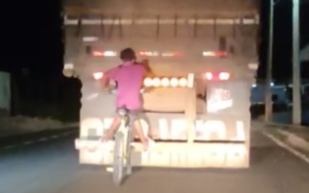 Dois homens pegam carona na traseira de caminhão em Goiás