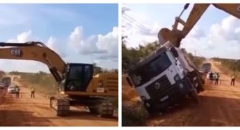 Escavadeira destombando caminhão no talento