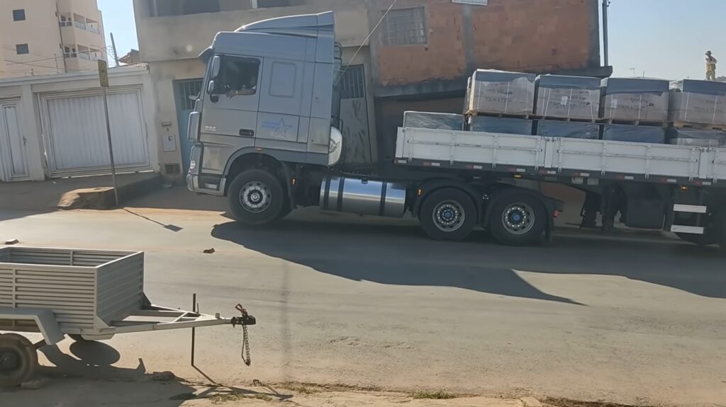 Caminhão DAF carregado de piso levantando a frente subindo a ladeira