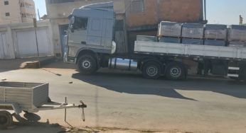 Caminhão DAF carregado de piso levanta a frente ao subir a ladeira