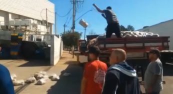 Caminhoneiro parado a dois dias esperando descarregamento joga mercadoria no chão