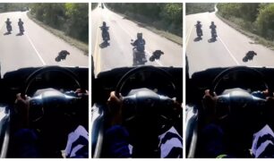 Dois motociclistas batem papo enquanto trafegam lentamente na frente de um caminhão carregado