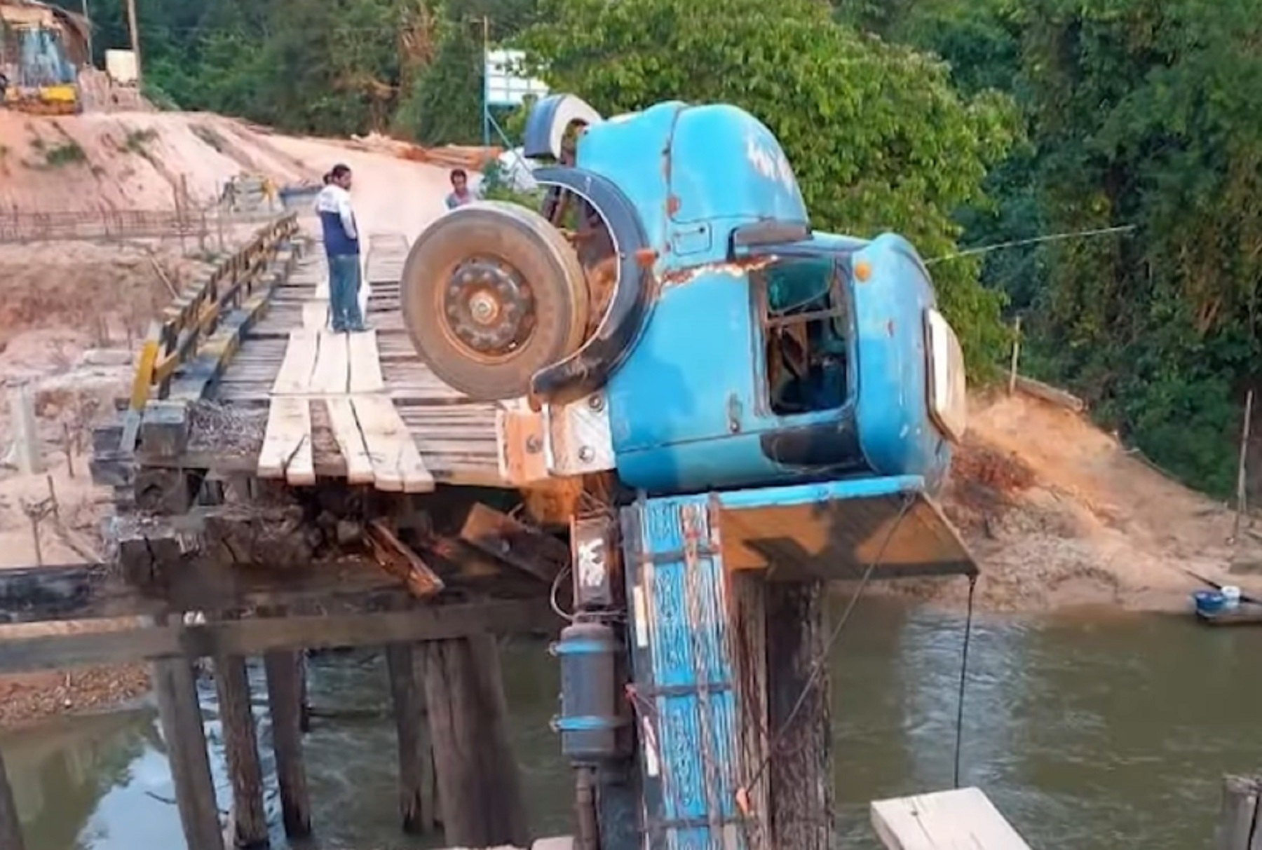Caminhão fica pendurado em ponte após estrutura ceder