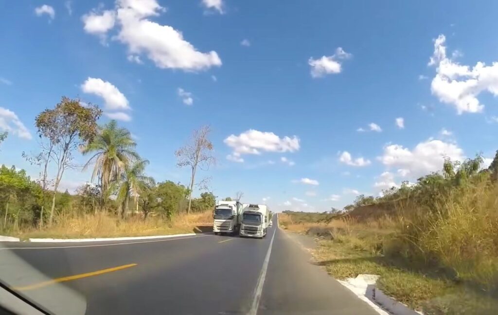 Motorista vai para acostamento para evitar colisão com caminhão realizando ultrapassagem proibida