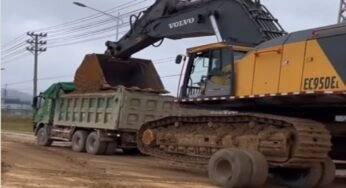 Caminhoneiro transporta retroescavadeira de uma forma diferente, mas não incomum para os profissionais