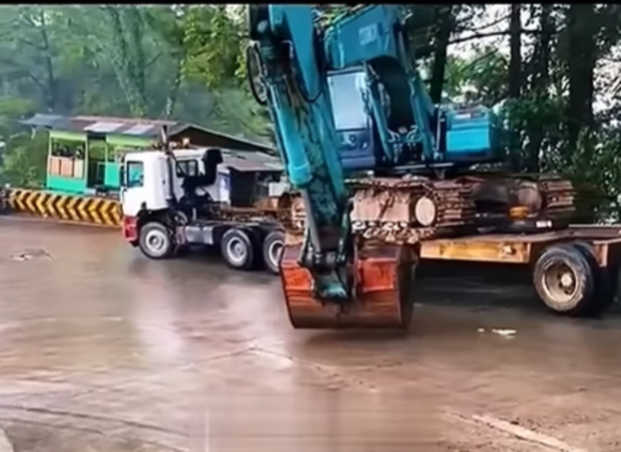 Caminhoneiro usa física a seu favor para conseguir trafegar com escavadeira hidráulica