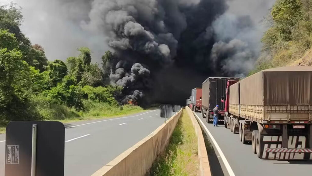 Caminhão carregado com diesel tomba, pega fogo e caminhoneiro é resgatado por colegas