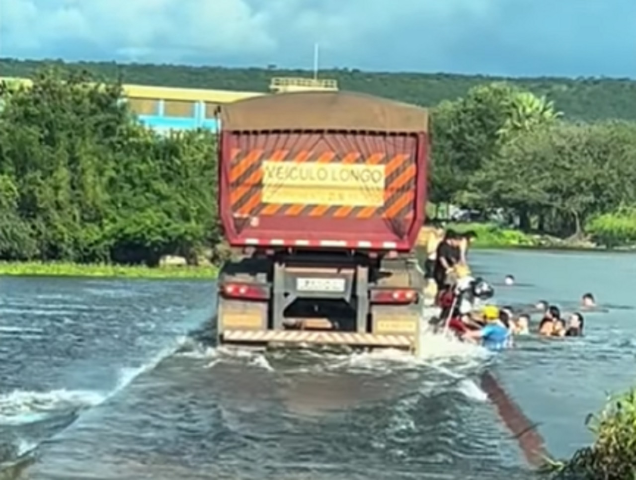 Caminhões trafegam por barragem submersa no Ceará