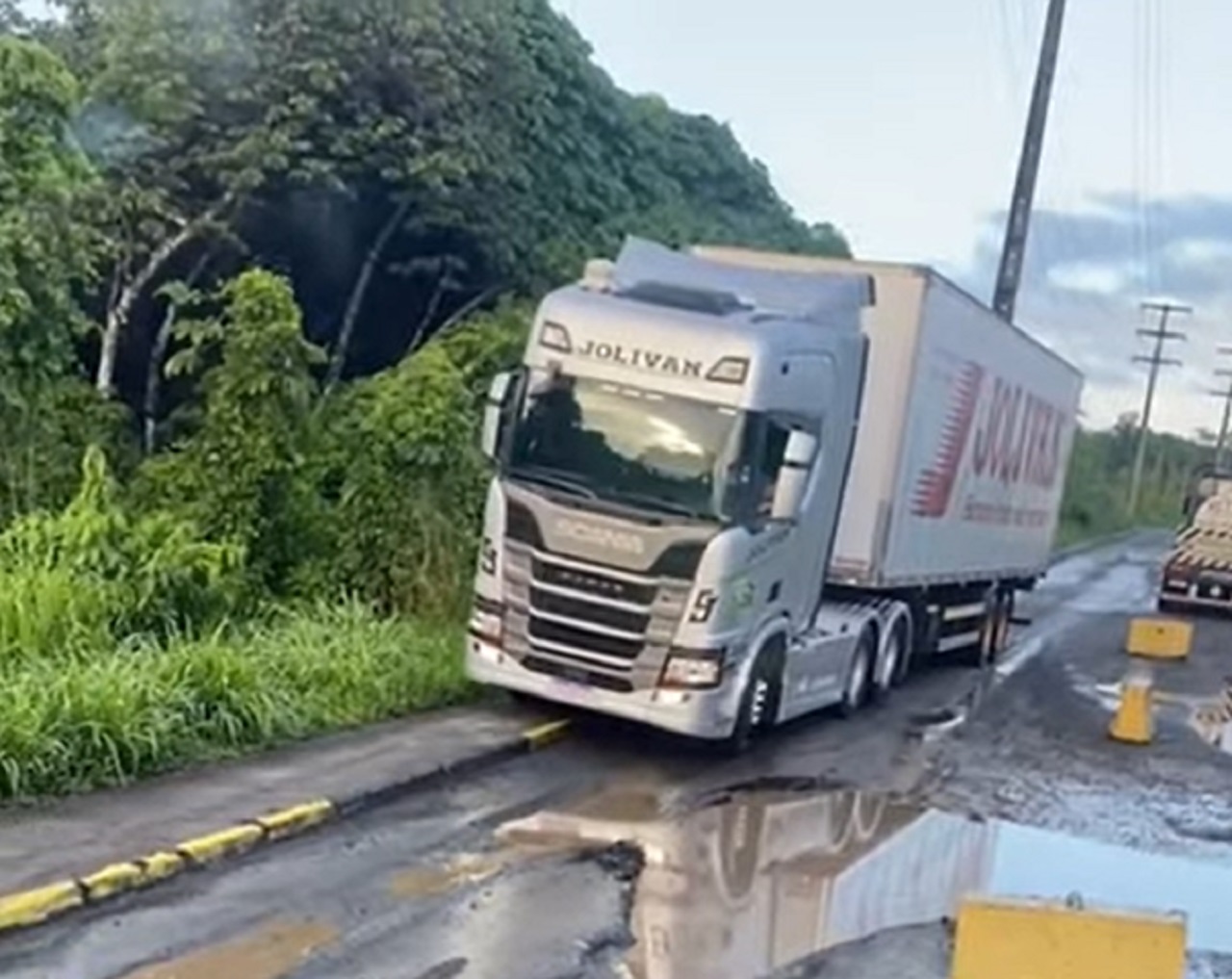 Caminhoneiro passa apuros em estrada esburacada e com lamaçal