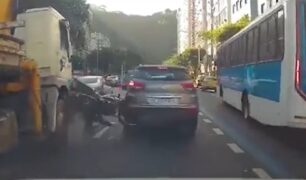 Motocicleta fica pendurada entre carro e caminhão em avenida