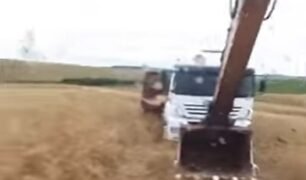 Caminhoneiro ilhado no meio do mato conta com a ajuda de pá escavadeira para sair do prego