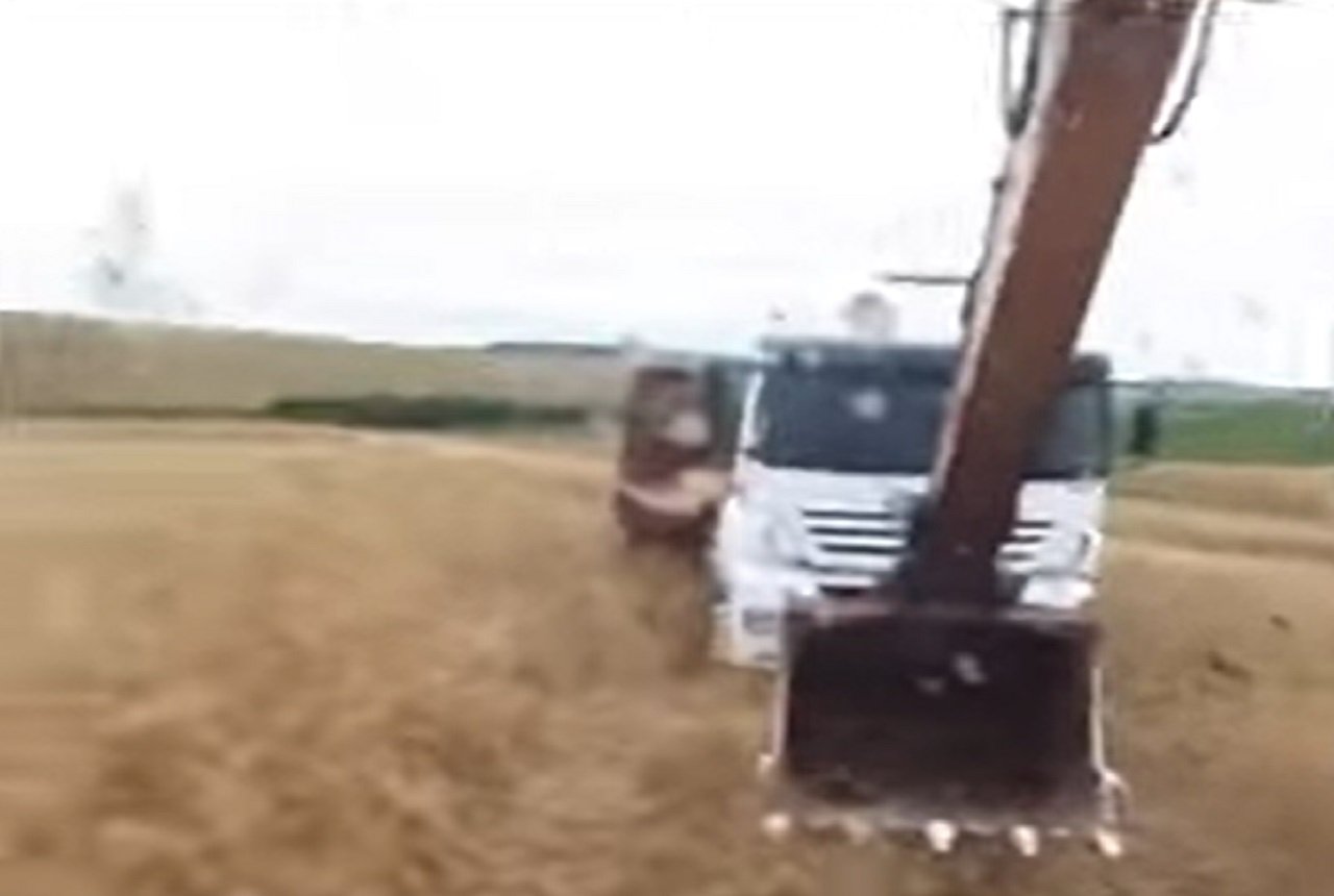 Caminhoneiro ilhado no meio do mato conta com a ajuda de pá escavadeira para sair do prego