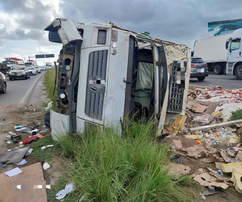 Caminhão tomba, motorista fica ferido e carga é saqueada