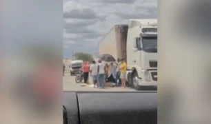 Acidente com caminhão e pessoas reunidas