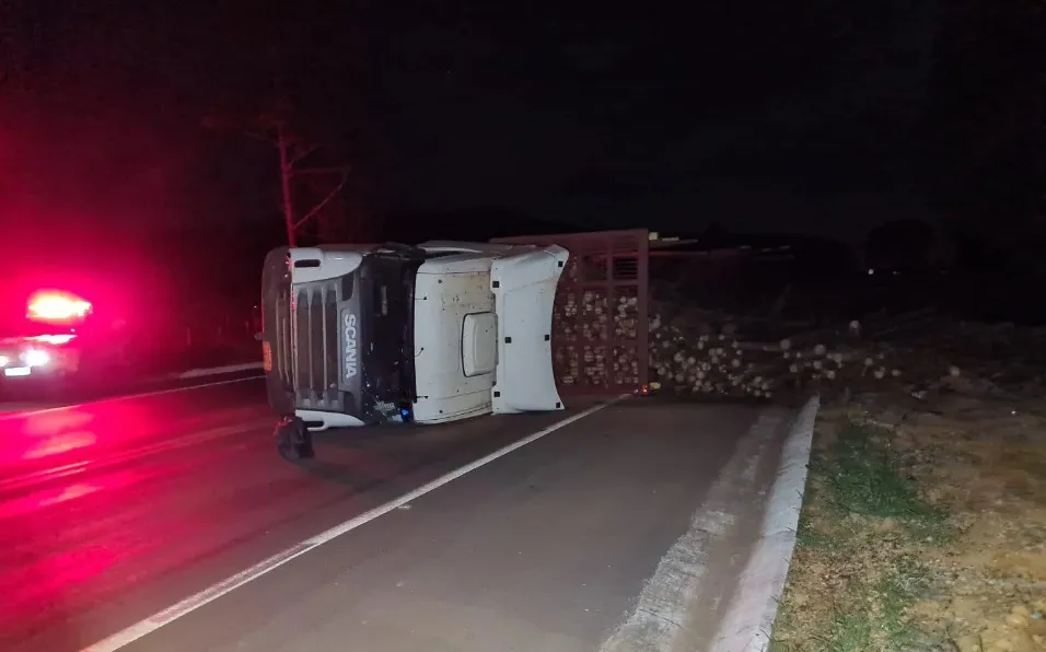 Caminhão que puxava 3 semi-reboques tomba com 70 toneladas de madeira