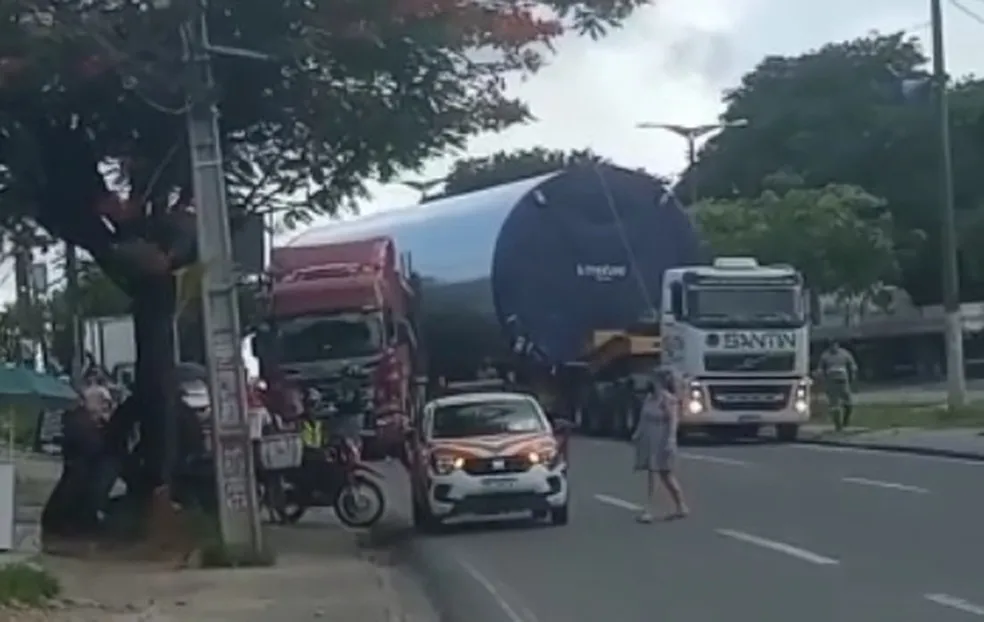 Carreta que transportava tubo de pá eólica provoca engarrafamento ao tentar passar por acidente entre caminhões na BR-101