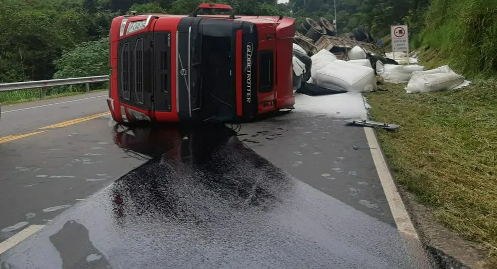 Na BR-393, em Barra do Piraí, uma carreta bitrem carregada com polietileno tomba e o motorista fica ferido