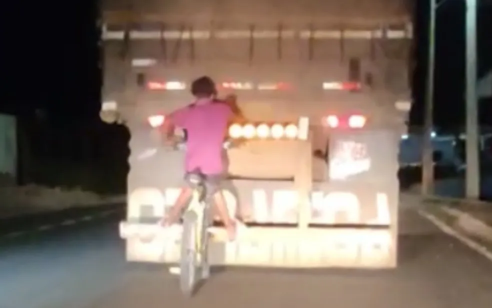 Dois homens pegam carona na traseira de caminhão em Goiás