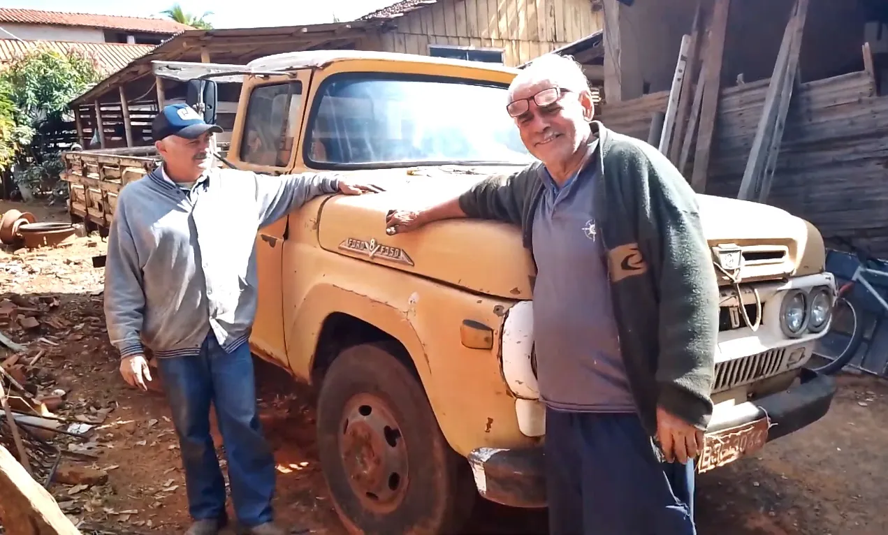 Idoso mostrando seu caminhão antigo