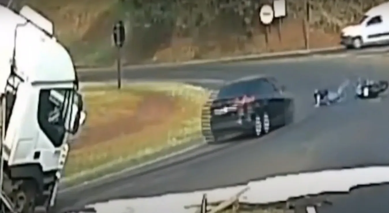 Motociclista cai após olhar para carreta que tombou em sua frente