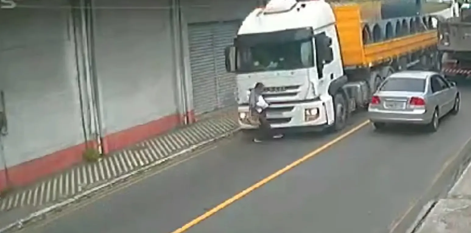 Homem se distrai ao atravessar a rua e acaba atropelado por caminhoneiro